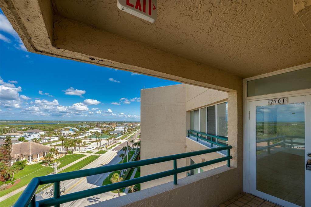 A balcony with a green railing overlooks a coastal street and residential area — 4535 S ATLANTIC AVENUE UNIT 2701, PORT ORANGE, FL