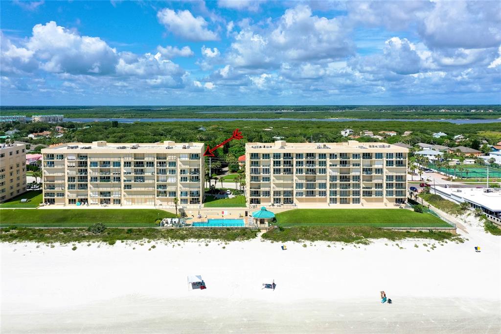 An aerial view shows two multi-story beachfront condominium buildings with a shared pool area — 4535 S ATLANTIC AVENUE UNIT 2701, PORT ORANGE, FL