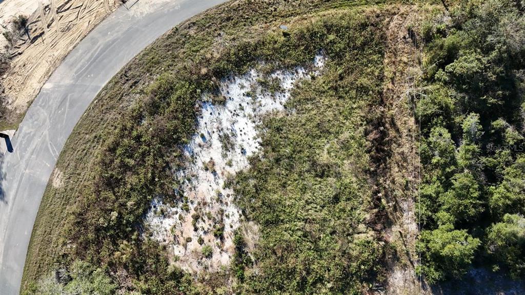 An aerial view shows a vacant, sandy lot bordered by a paved road and trees — 15800 SW 37TH CIRCLE, OCALA, FL