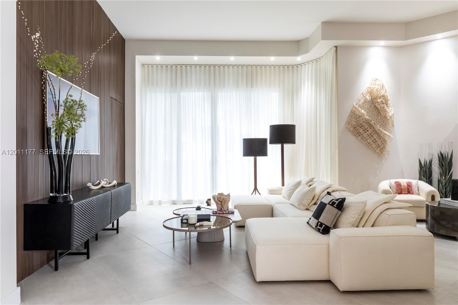 A modern living room features a white sectional sofa, a dark media console, and floor-to-ceiling curtains — 808 Brickell Key Dr # 408, Miami FL 33131, MIAMI, FL