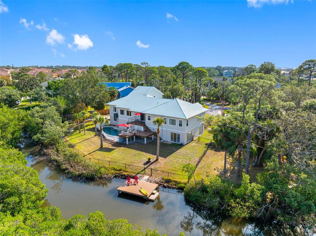 An aerial view shows a two-story house with a pool, deck, and private dock — 1580 MACCHESNEY DRIVE, TARPON SPRINGS, FL