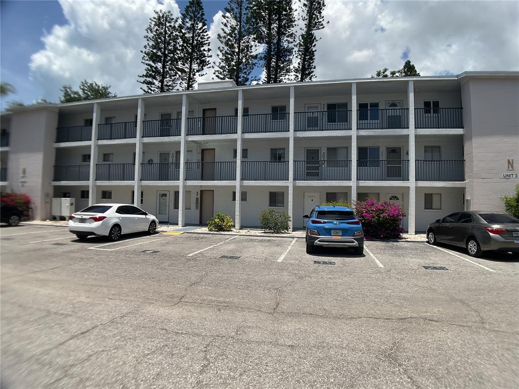 A three-story apartment building with exterior walkways and a parking lot in front — 2021 CANAL DRIVE UNIT N25, BRADENTON, FL