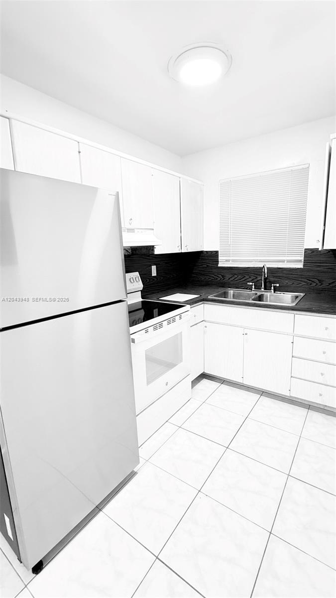A kitchen features white cabinets, a stainless steel refrigerator, a white stove, and tiled floors — 400 SE 9th Ct # 9, Hallandale Beach FL 33009, HALLANDALE BEACH, FL