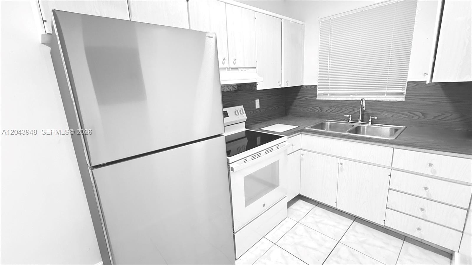 A kitchen features white cabinets, a stainless steel refrigerator, a white stove, and tile flooring — 400 SE 9th Ct # 9, Hallandale Beach FL 33009, HALLANDALE BEACH, FL
