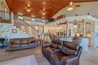 A living room with brown leather sofas, a wooden ceiling, and an open kitchen area — 1740 NW 20TH AVENUE, CRYSTAL RIVER, FL