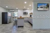 A kitchen features a central island with bar stools, stainless steel appliances, and light flooring — 1740 NW 20TH AVENUE, CRYSTAL RIVER, FL
