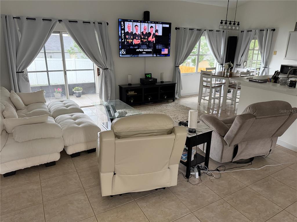 A single-story house with white stucco walls, a pink garage door, and a palm tree — 2001 JAFFA COURT, CLERMONT, FL