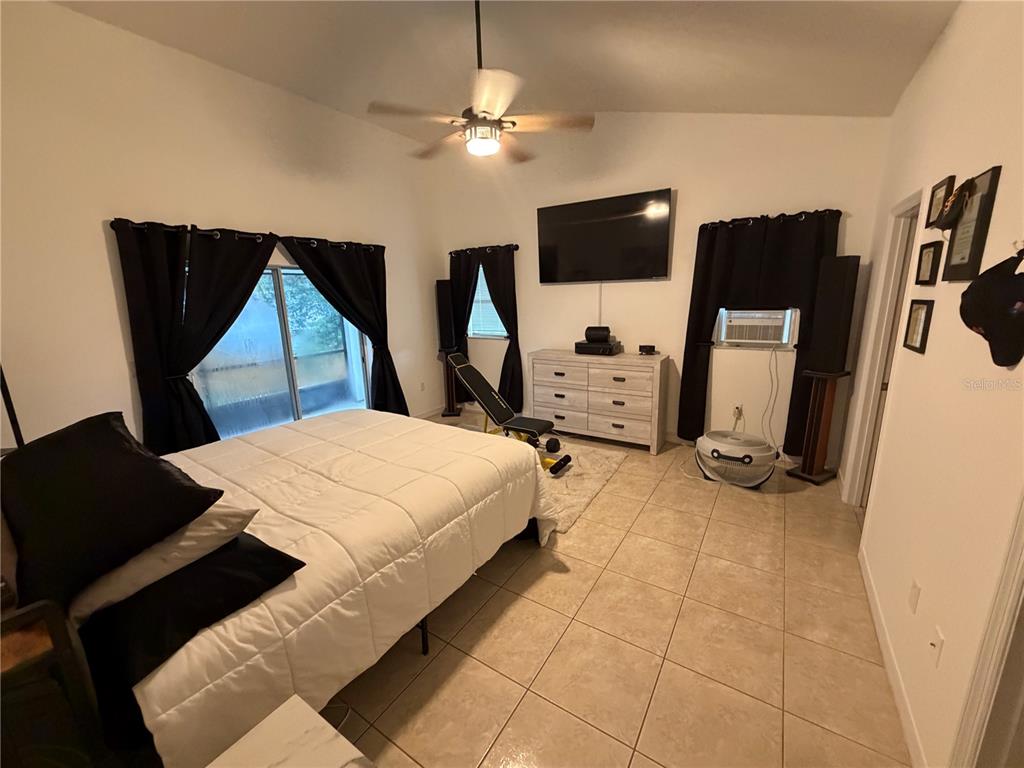 A living room with tile floors, a vaulted ceiling, and an open kitchen area — 2001 JAFFA COURT, CLERMONT, FL