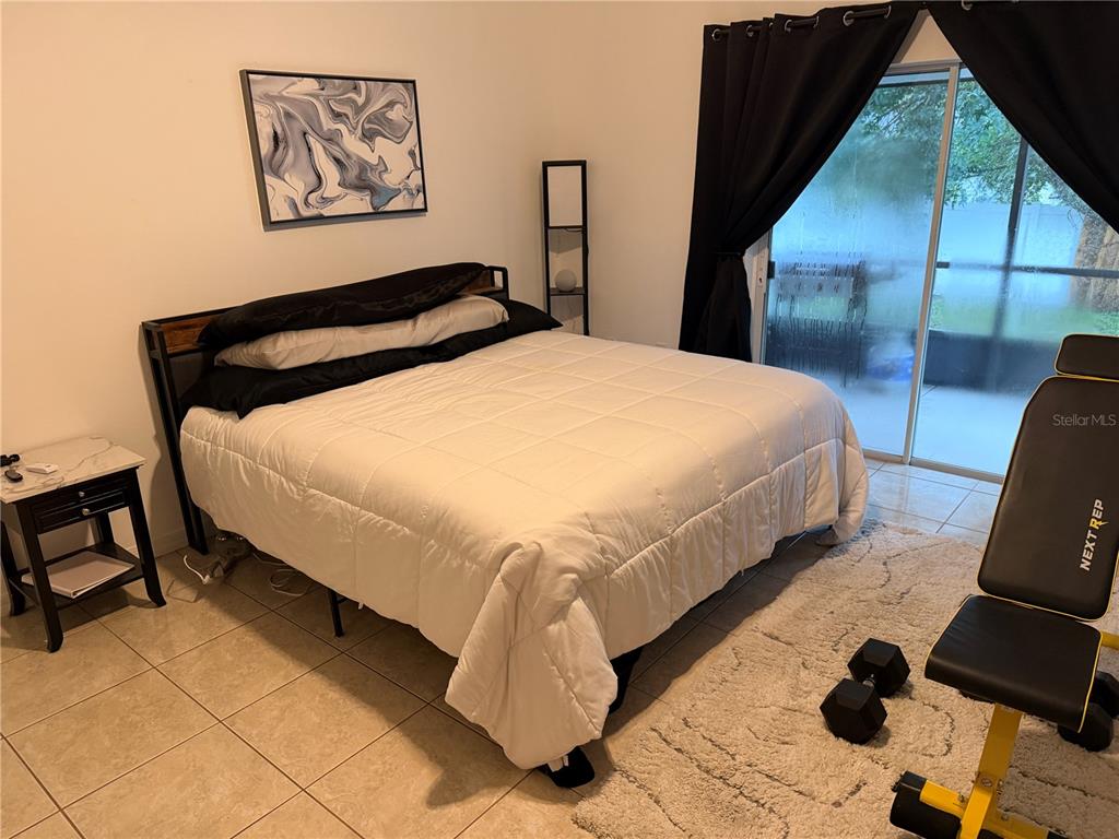 An open-concept living and dining area features tile flooring, white furniture, and a ceiling fan — 2001 JAFFA COURT, CLERMONT, FL