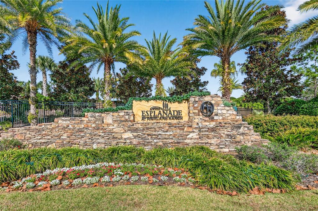 A stone monument sign for Esplanade at Highland Ranch sits before palm trees and landscaping — 1284 ZEEK RIDGE STREET, CLERMONT, FL