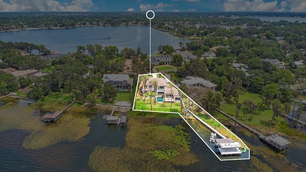 An aerial view shows a waterfront house with a pool and a private boat dock — 724 W 2ND AVENUE, WINDERMERE, FL