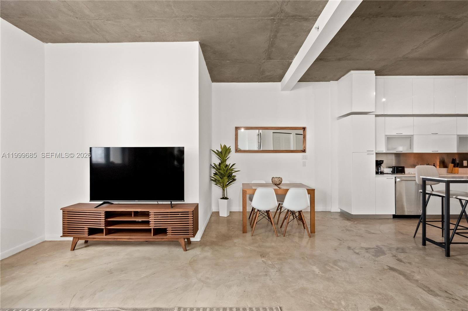 A living and dining area features a concrete ceiling, white walls, and polished concrete floors — 234 NE 3rd St # 1704, Miami FL 33132, MIAMI, FL