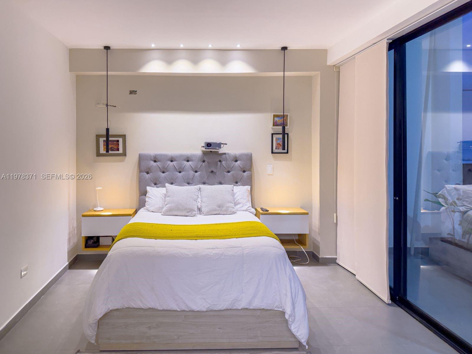 A bedroom features a tufted gray headboard, floating nightstands, and a yellow throw blanket — 150 Manantial Mercededs, 764001, FL