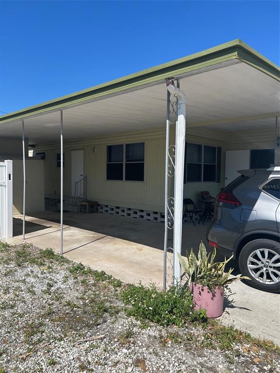 A light-colored mobile home features a covered carport and a parked SUV — 2574 ARBELIA STREET, CLEARWATER, FL