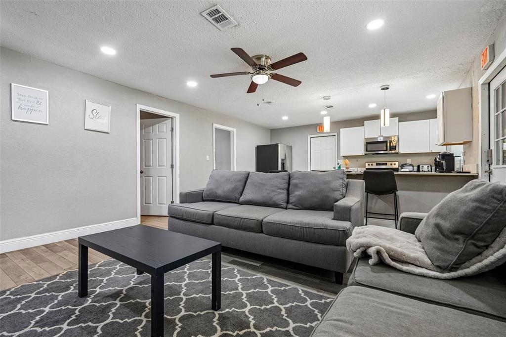 A living room features a grey sofa, a black coffee table, and an open kitchen — 520 FAIRFAX LANE, APOLLO BEACH, FL
