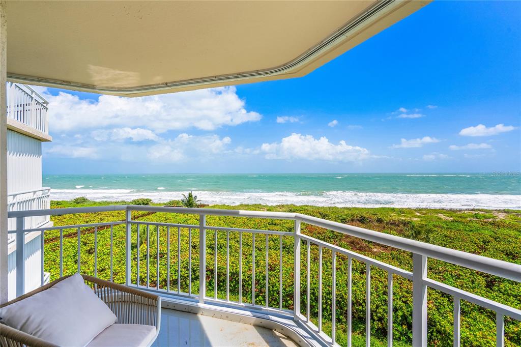 A balcony with a white railing overlooks a sandy beach and the ocean — 3870 N HIGHWAY A1A UNIT 405, FORT PIERCE, FL