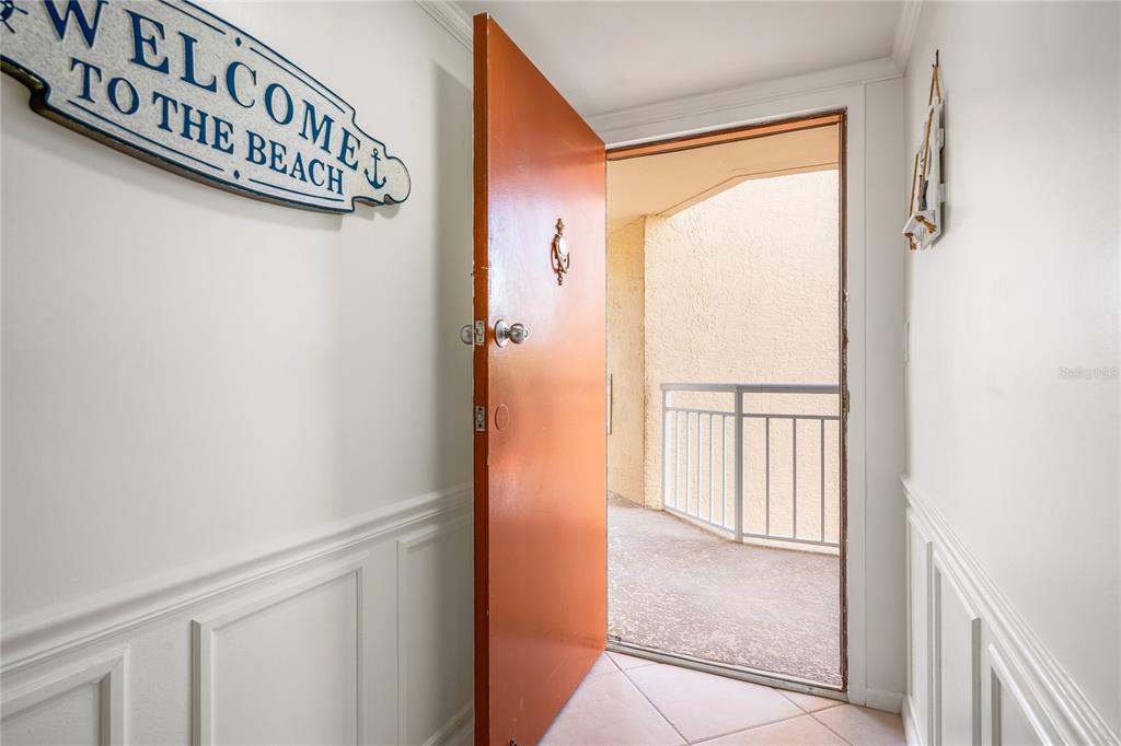An open orange door leads from a white hallway to an outdoor balcony — 3870 N HIGHWAY A1A UNIT 405, FORT PIERCE, FL