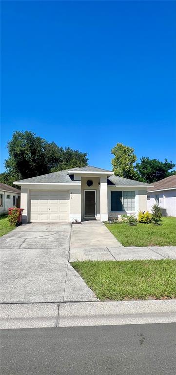 A single-story house with a white exterior, a garage, and a front lawn under blue sky — 409 ABIGAIL ROAD, PLANT CITY, FL