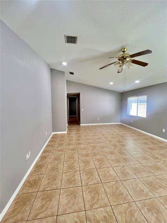 A spacious room with gray walls, tan tile flooring, and a ceiling fan — 409 ABIGAIL ROAD, PLANT CITY, FL