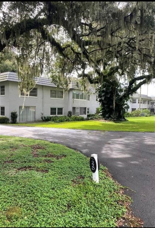 A two-story apartment building sits behind a large oak tree with a driveway in front — 220 N IDLEWOOD AVENUE UNIT 204, BARTOW, FL