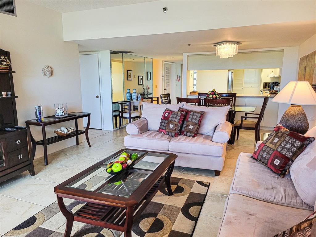 A living room features light-colored sofas, a glass-topped coffee table, and an adjacent dining area — 1105 GULF OF MEXICO DRIVE UNIT 402, LONGBOAT KEY, FL