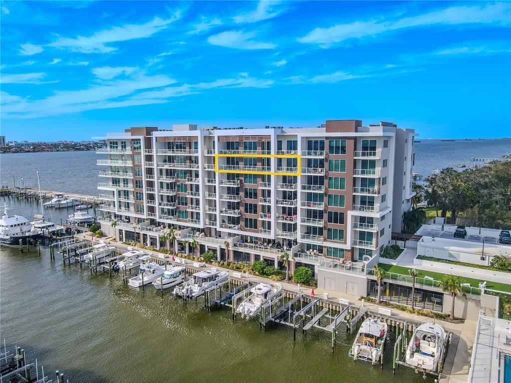 An aerial view of a multi-story waterfront condominium building with a highlighted balcony level — 920 N OSCEOLA AVENUE UNIT 703, CLEARWATER, FL