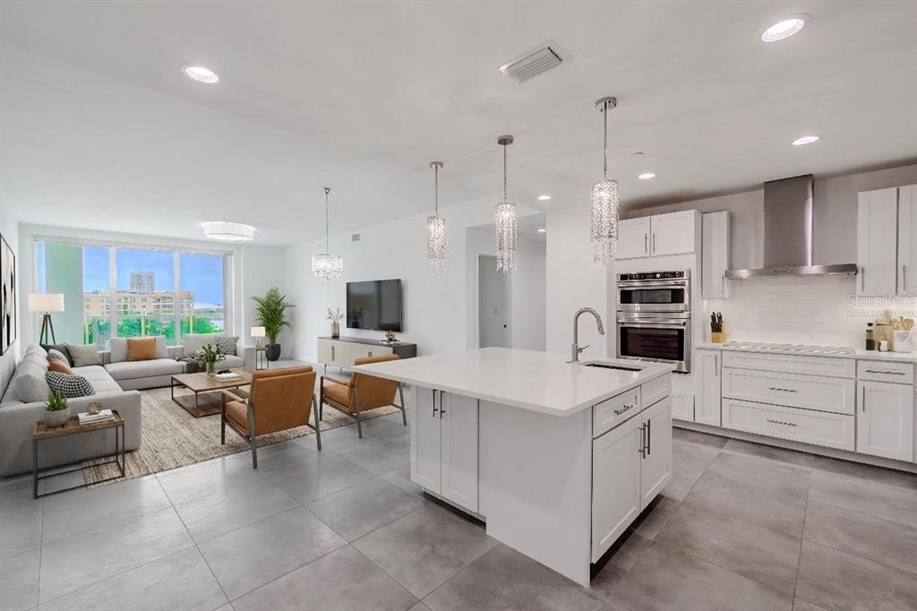 A modern open-concept kitchen and living area with white cabinetry, a large island, and tile — 920 N OSCEOLA AVENUE UNIT 703, CLEARWATER, FL