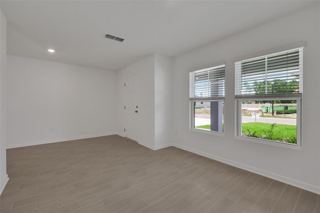 An empty room with light-colored tile flooring, white walls, and two windows with blinds — 3770 HOLSTEIN WAY, GREEN COVE SPRINGS, FL