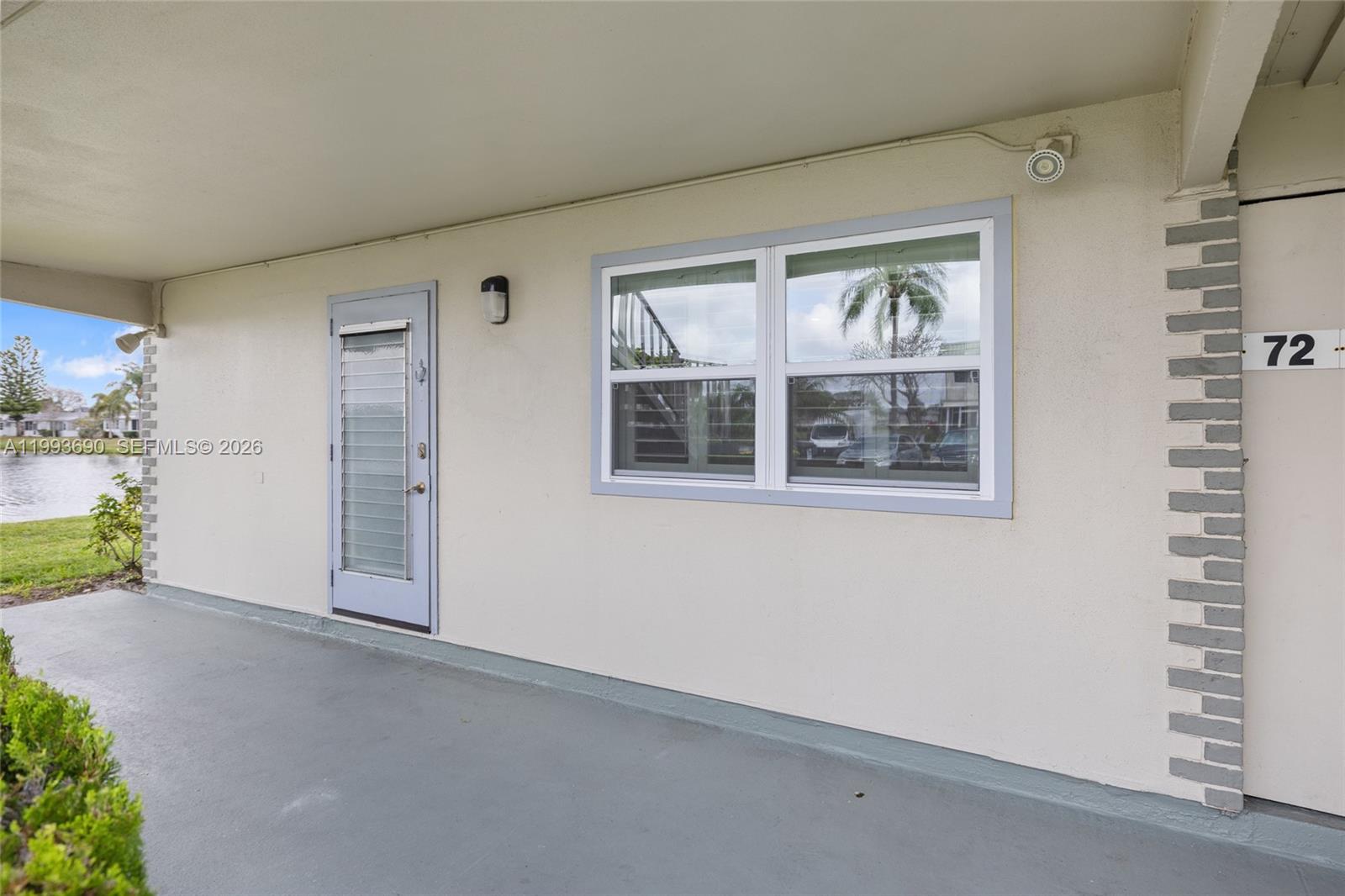 The exterior of a ground-level unit features a gray door, a window, and number 72 — 72 Monaco B # 72, Delray Beach FL 33446, DELRAY BEACH, FL