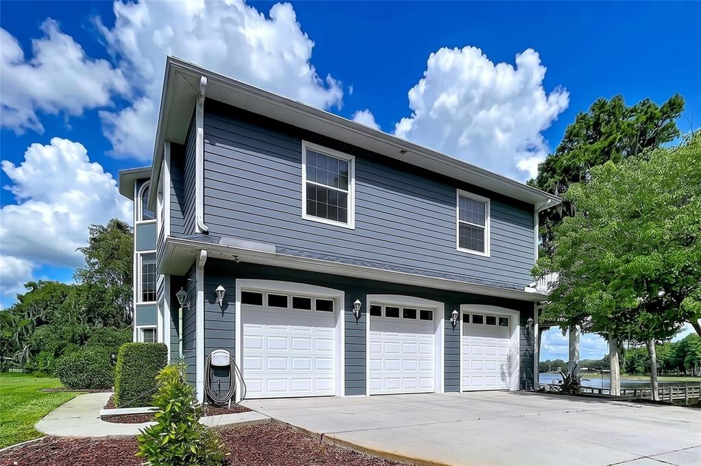 A two-story house with blue horizontal siding and a three-car garage — 1360 S WATERVIEW DRIVE, INVERNESS, FL