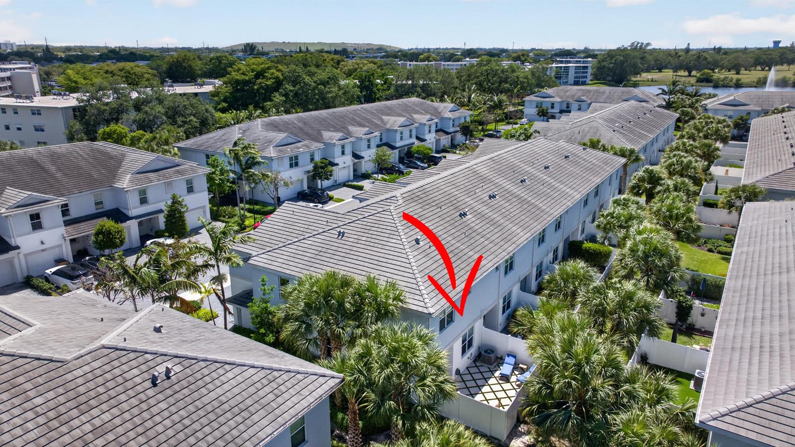 An aerial view shows a multi-story townhouse complex with a red arrow pointing toward a patio — 1835 Sandpiper Pointe Place, Deerfield Beach FL 33442, DEERFIELD BEACH, FL