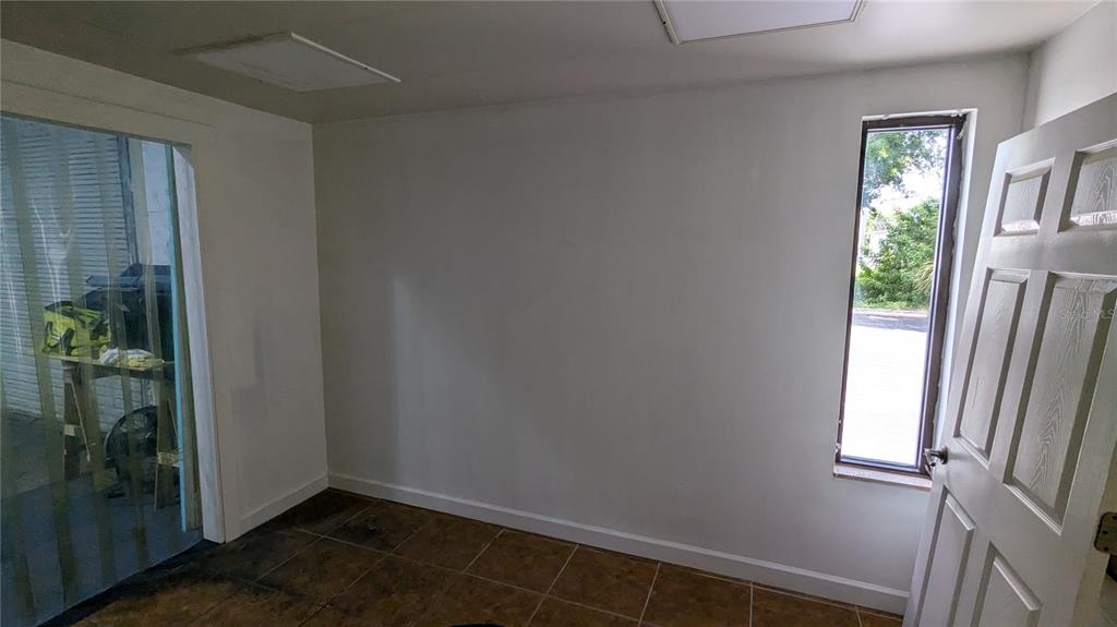 An interior room with white walls, tile flooring, a window, and an open door — 11920 31ST COURT N, ST PETERSBURG, FL