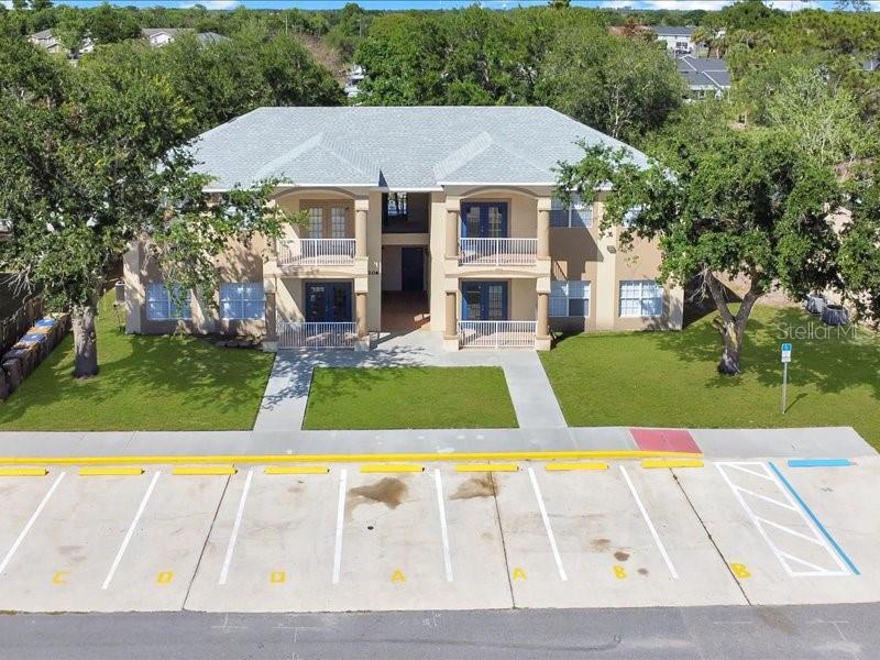 An aerial view of a two-story apartment building with a parking lot in front — 206 MAJORS LANE UNIT A, KISSIMMEE, FL