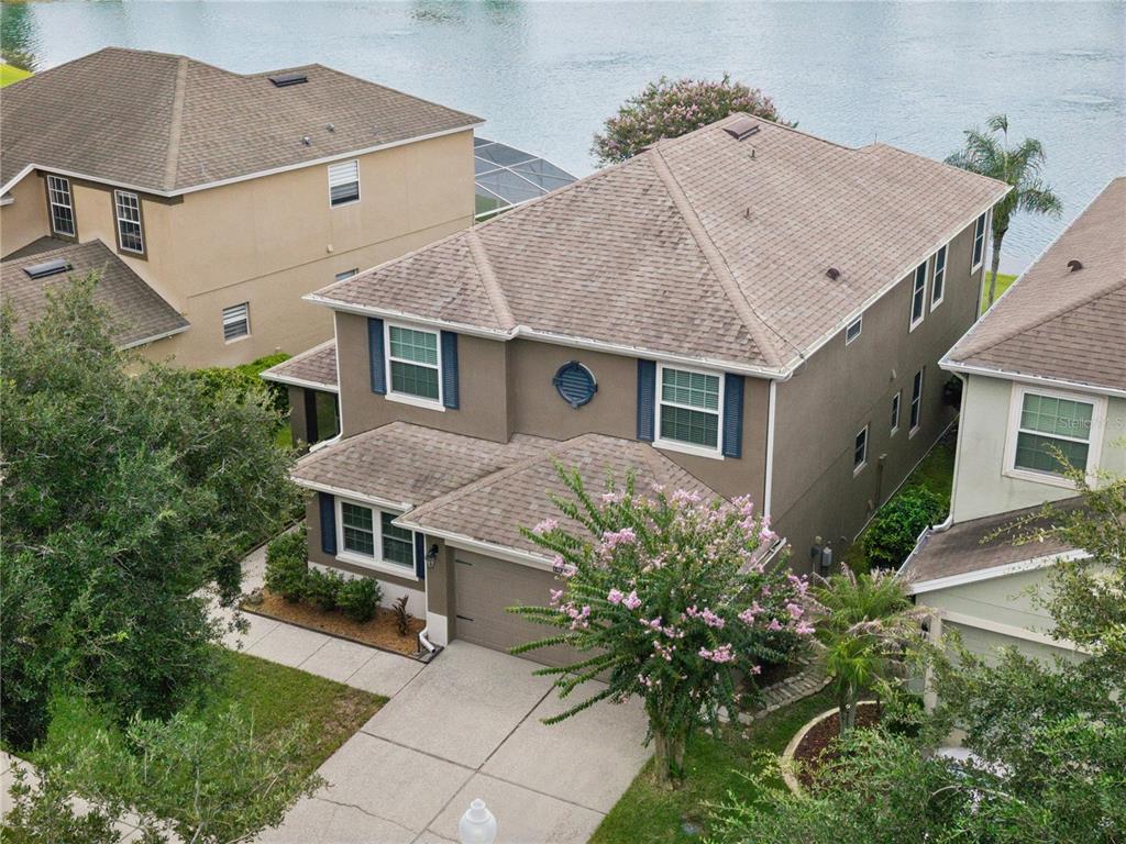 An aerial view shows a two-story suburban house with a brown roof and driveway — 14827 MASTHEAD LANDING CIRCLE, WINTER GARDEN, FL