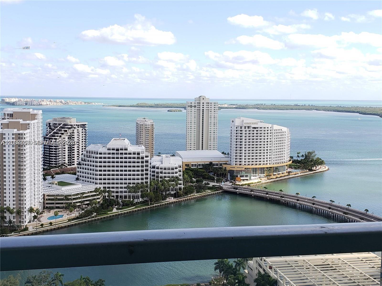 An elevated view shows high-rise buildings, a bridge, and the ocean in Miami — 500 Brickell Ave # 2102, Miami FL 33131, MIAMI, FL