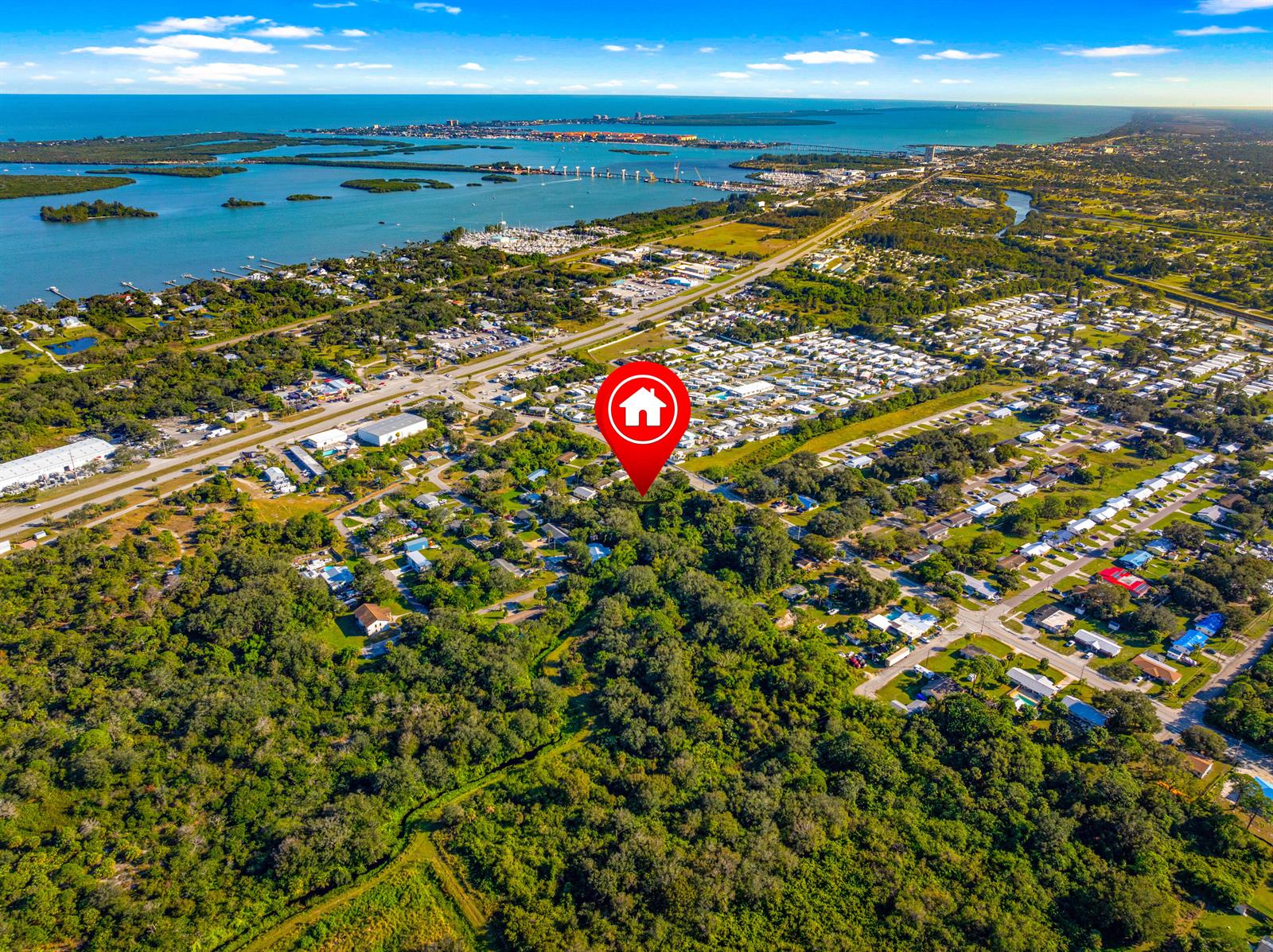 An aerial view shows a red house icon marking a wooded lot near a coastal town — 2210 Saint Lucie Boulevard, Fort Pierce FL 34946, FORT PIERCE, FL