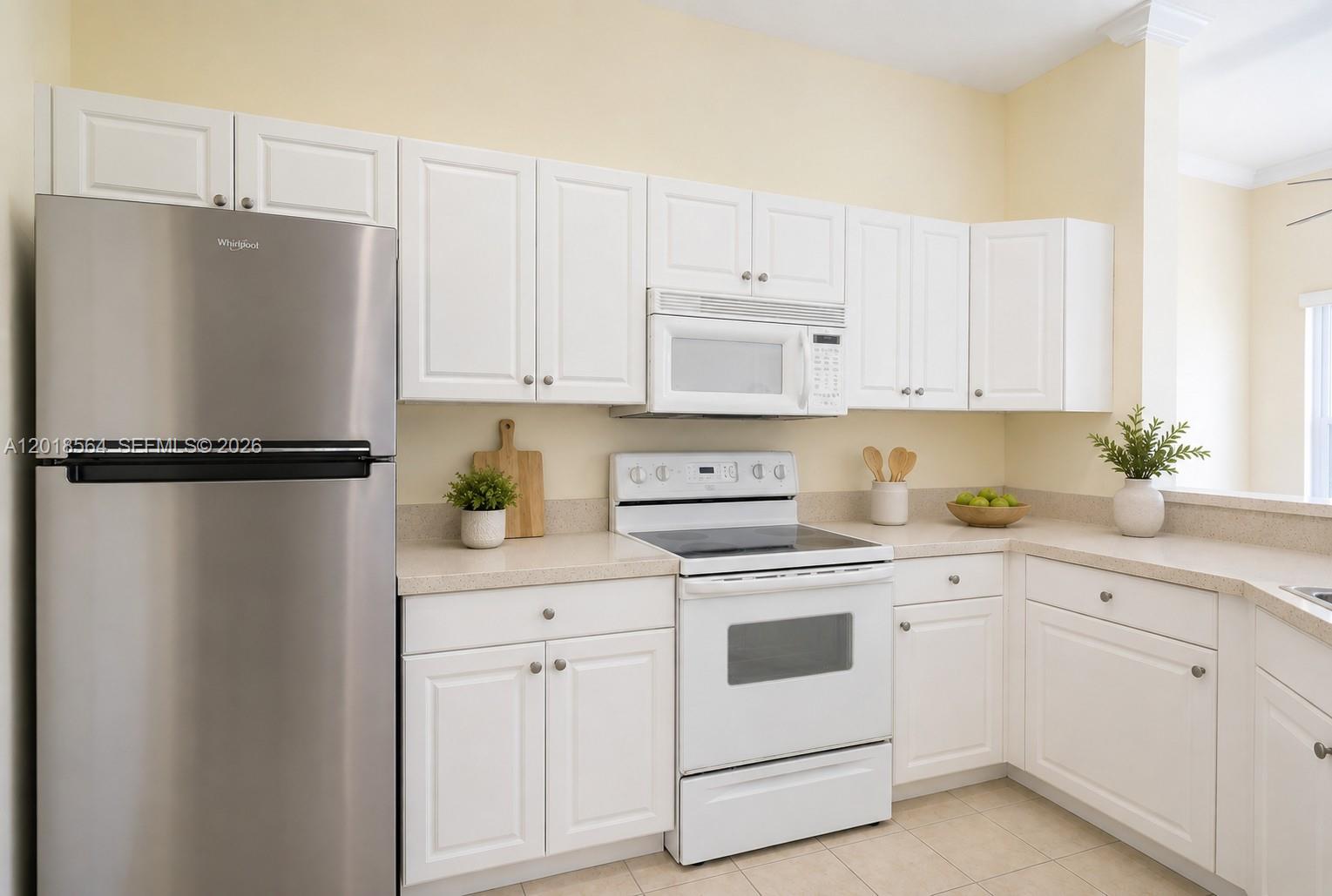 A kitchen features white cabinets, stainless steel appliances, and light-colored countertops — 4402 SW 160th Ave # 934, Miramar FL 33027, MIRAMAR, FL