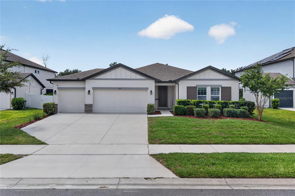 A single-story suburban house with a three-car garage and a manicured front lawn — 1113 PEARL TREE ROAD, DELTONA, FL