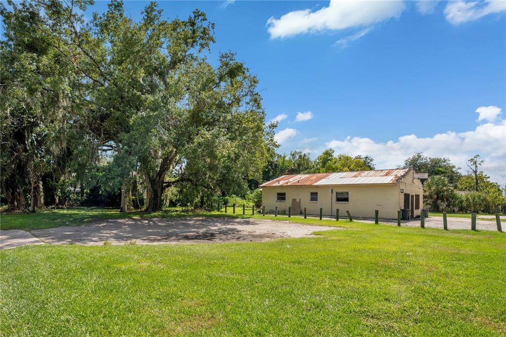 A grassy lot features a small, weathered building with a rusted metal roof — 1401 HISTORIC GOLDSBORO BOULEVARD, SANFORD, FL