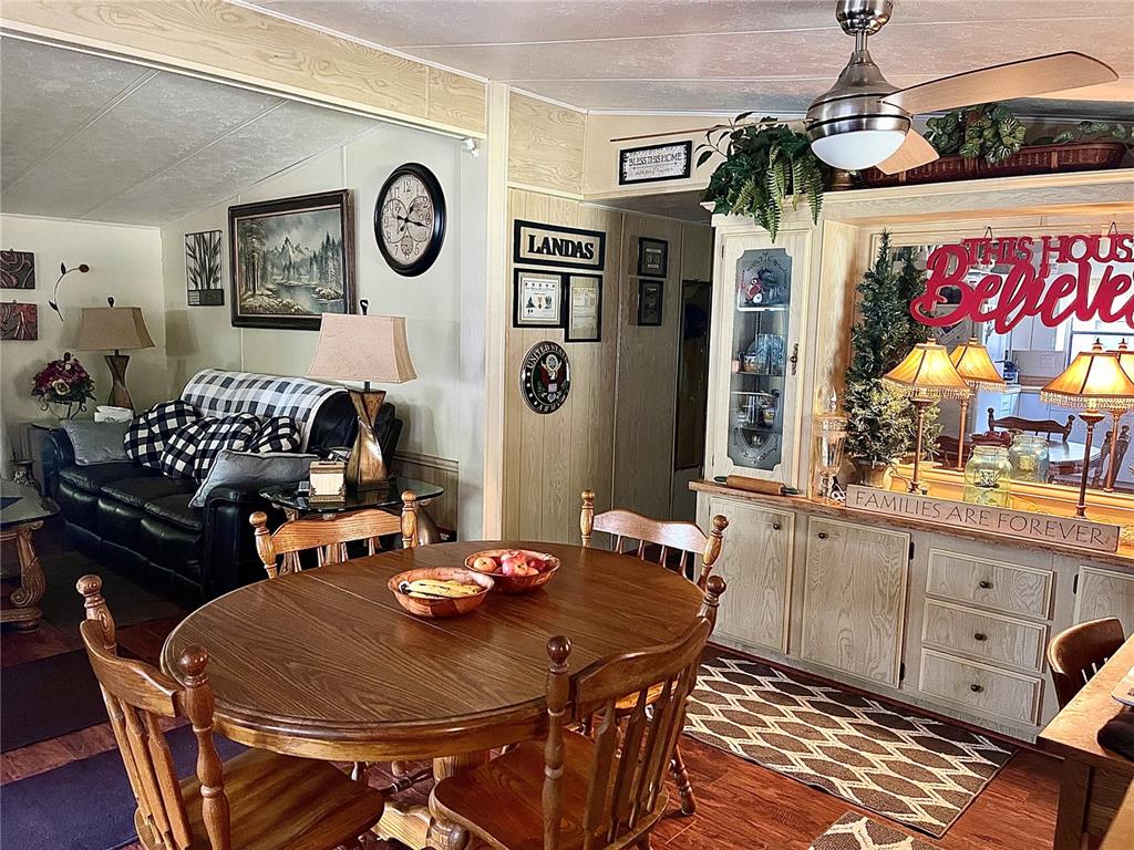 A dining area with a wooden table and chairs sits adjacent to a living room — 900 AQUA ISLES BOULEVARD UNIT B21, LABELLE, FL
