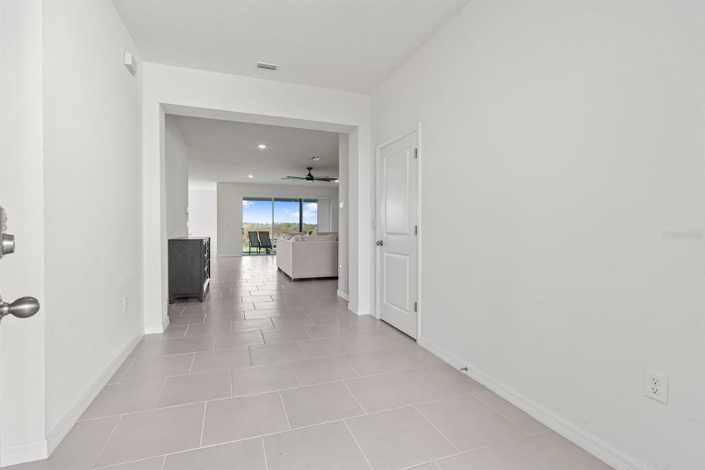 A bright entryway with light tile flooring leads into an open-concept living area — 3507 GOLDEN WHEAT LANE, PLANT CITY, FL