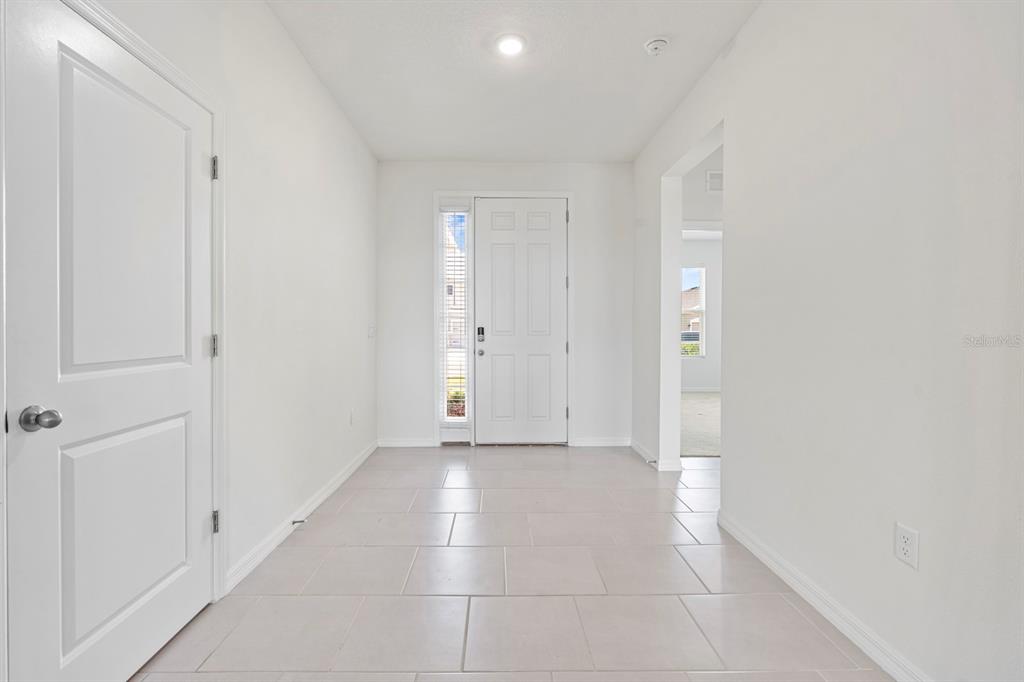 A bright entryway features white walls, light-colored tile flooring, and a white front door — 3507 GOLDEN WHEAT LANE, PLANT CITY, FL