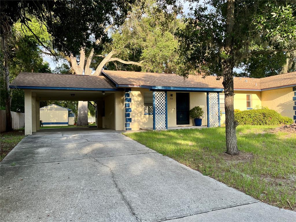 A single-story house with a carport, a concrete driveway, and a front porch with lattice — 705 BAYOU AVENUE, TARPON SPRINGS, FL