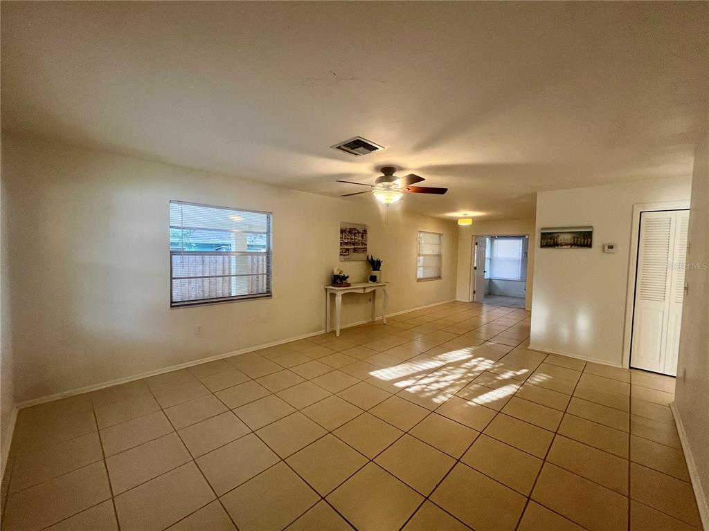 A living room features light-colored tile flooring, a ceiling fan, and a white console table — 705 BAYOU AVENUE, TARPON SPRINGS, FL