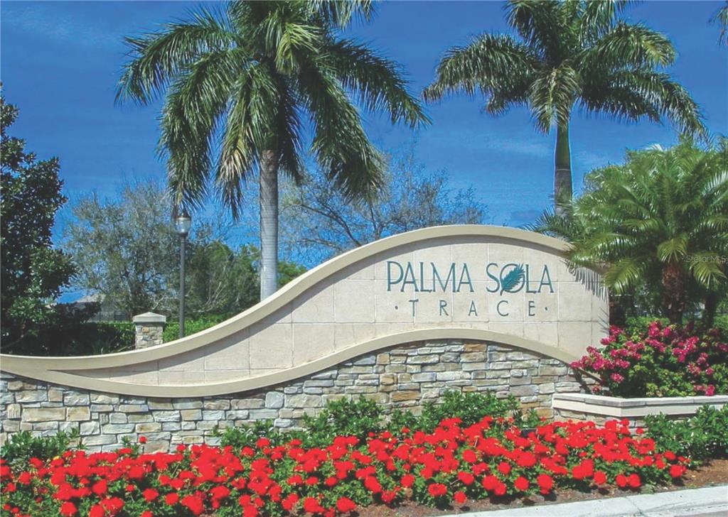 A stone community entrance sign for Palma Sola Trace is surrounded by palm trees and flowers — 7321 SKYBIRD ROAD UNIT 397, BRADENTON, FL