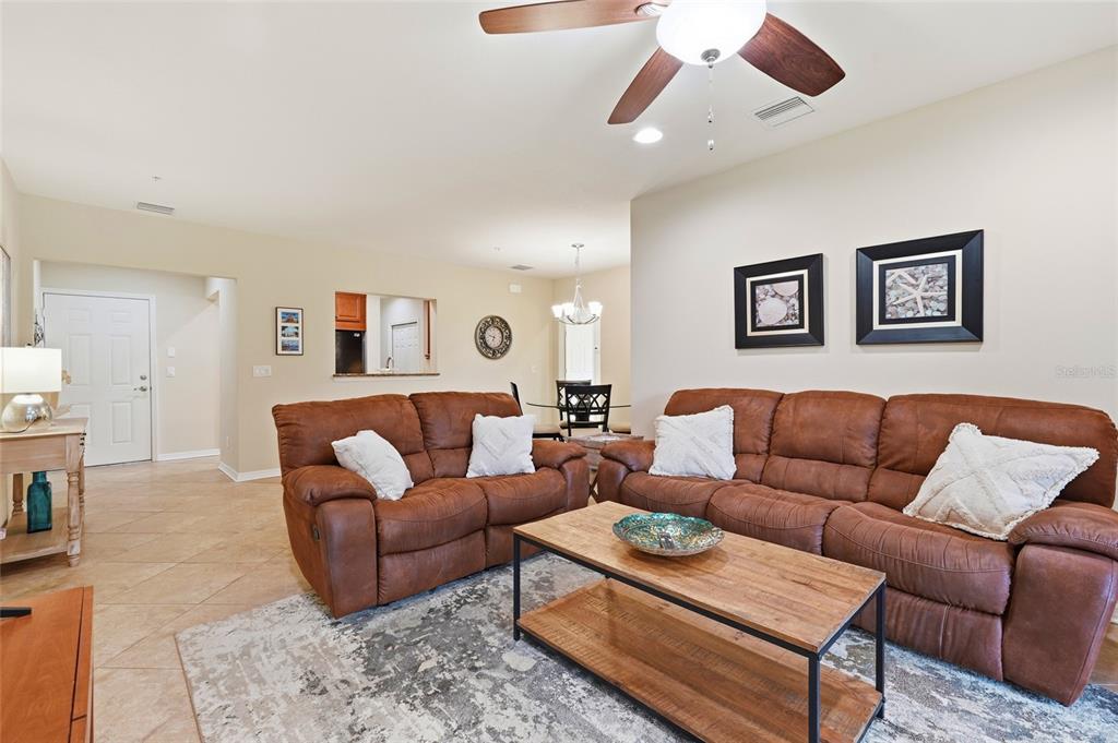 A living room features brown leather sofas, a wooden coffee table, and tile flooring — 7321 SKYBIRD ROAD UNIT 397, BRADENTON, FL