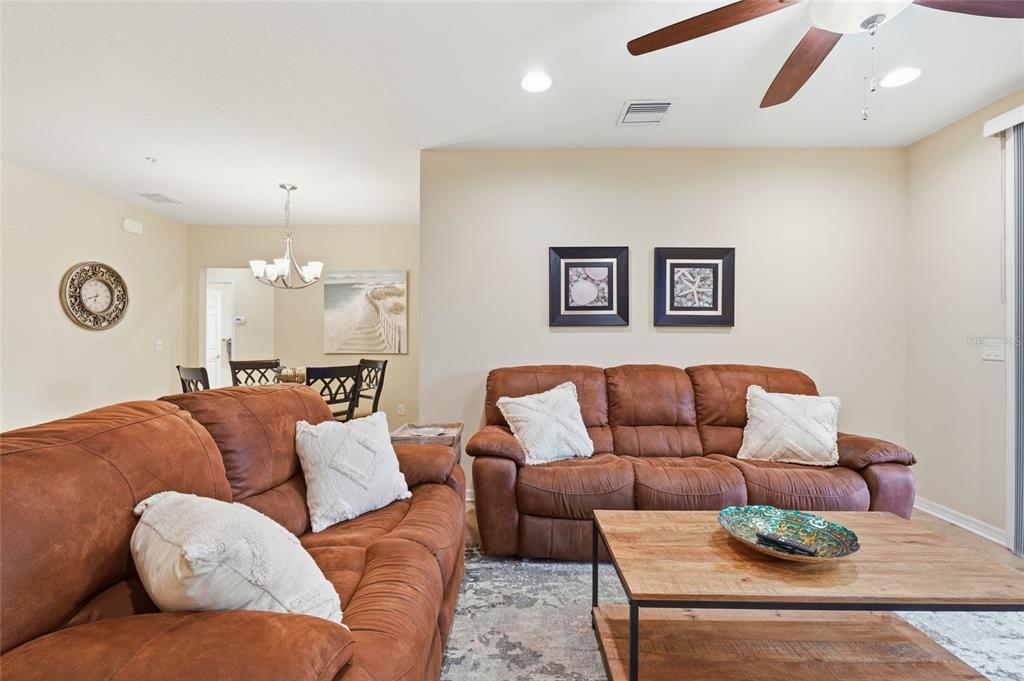 A living room features two brown leather sofas, a wooden coffee table, and wall art — 7321 SKYBIRD ROAD UNIT 397, BRADENTON, FL