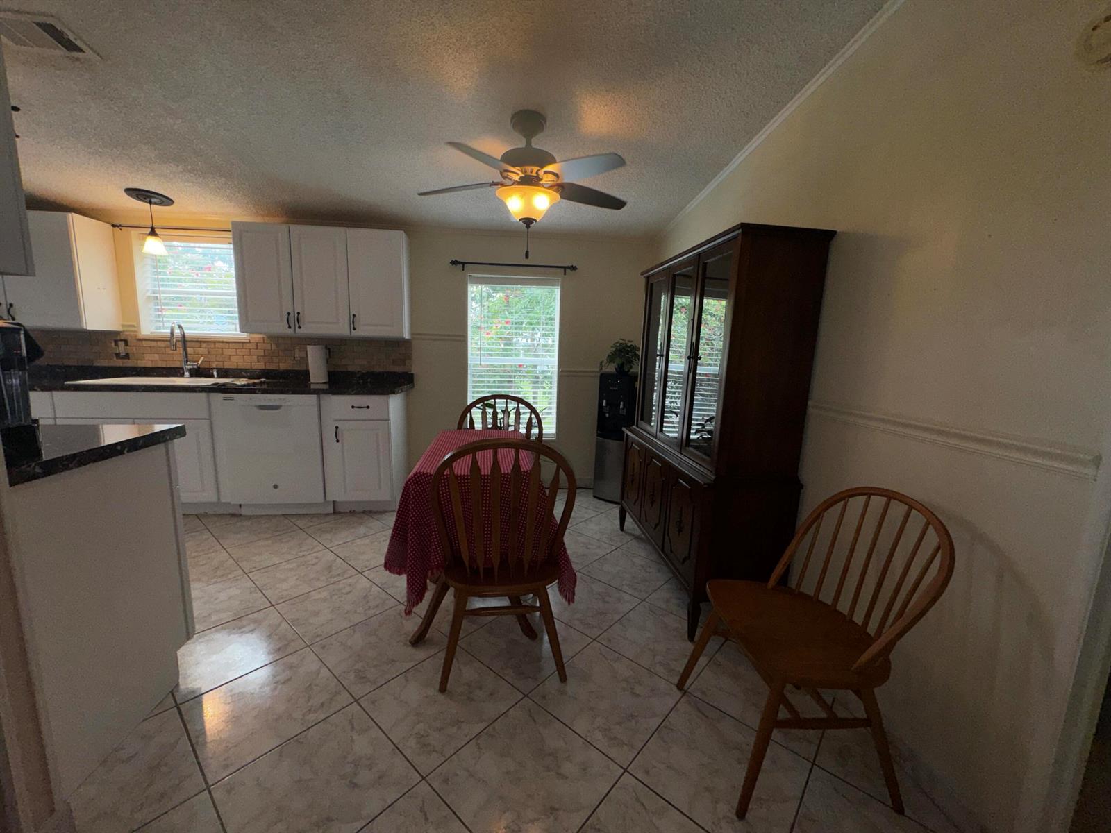 A kitchen with white cabinets, tile flooring, a dining table, and a wooden hutch — 4081 4th Court, Lantana FL 33462, LANTANA, FL