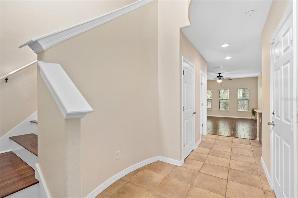 A tiled entryway leads to a staircase and a hallway with hardwood flooring — 6058 TIVOLI GARDENS BOULEVARD, ORLANDO, FL