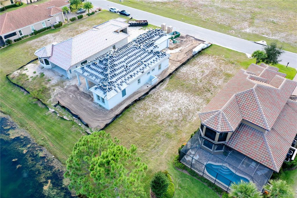 An aerial view shows a house under construction next to a completed home with a pool — 355 HIBISCUS WAY, PALM COAST, FL